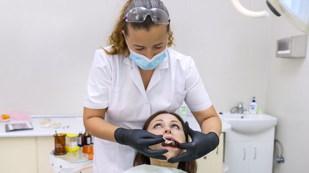 Una trabajadora de una clínica dental con una paciente