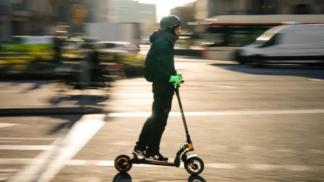 Un hombre en su patinete Un hombre conduce un patinete eléctrico por una vía