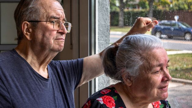 Una pareja de jubilados mirando por la ventana