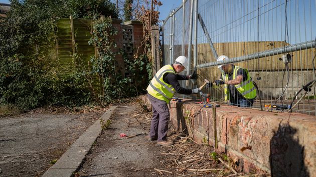 Trabajadores arreglando una valla 