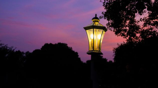 Farola iluminada durante el final de un atardecer