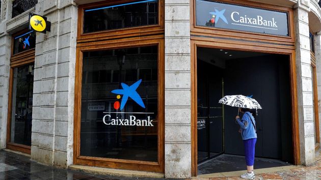 Una mujer esperando en el cajero de una oficina de CaixaBank
