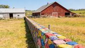 Un campo separado por un muro de piedras de colores.