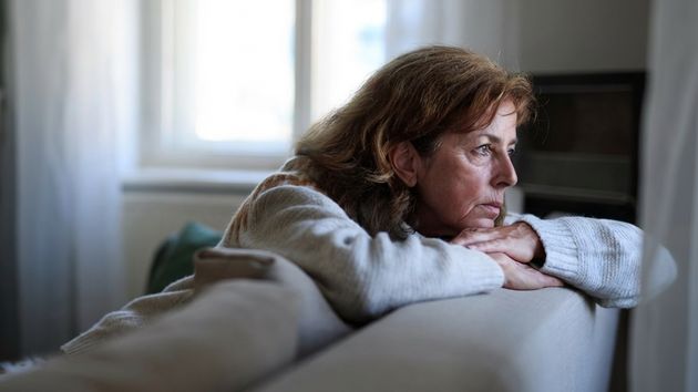 Una mujer con cara triste, en el sofá