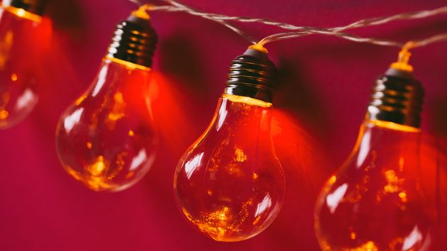 Guirnalda de luces encendida, sobre fondo rojo