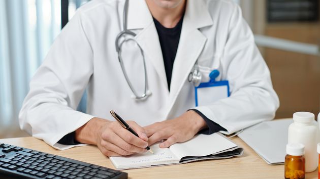 Un médico dando la baja médica