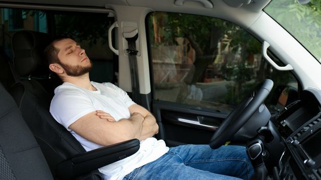 Un hombre durmiendo en un coche 