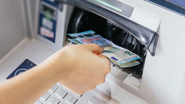 Una persona sacando dinero de un cajero