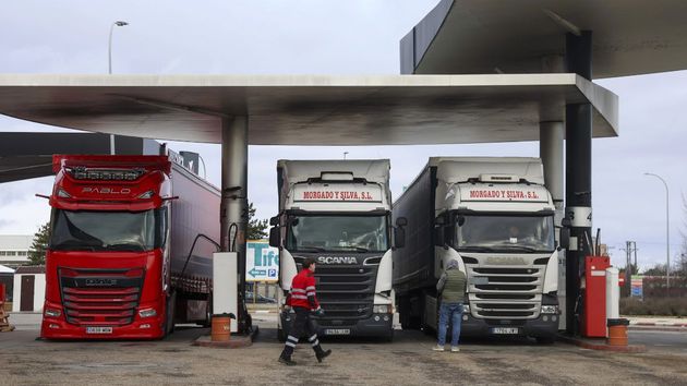 tres camiones en una gasolinera