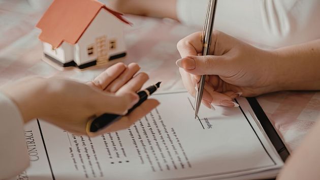Personas firmando un contrato inmobiliario