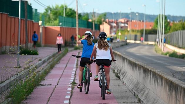 unas niñas en bici por un carril bici