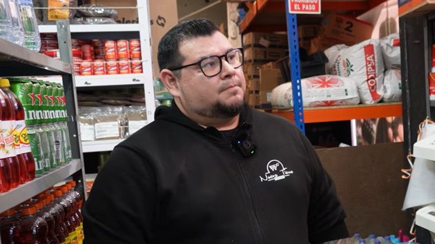 un hombre delante de estanterías con productos