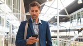 Un hombre viajando por trabajo consultando su móvil