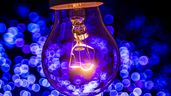 Una bombilla de luz encendida con destellos azules