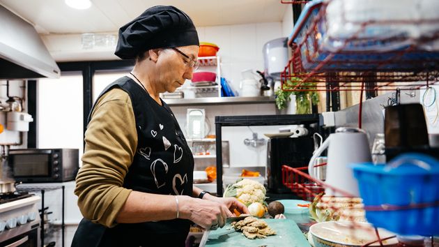 Una mujer mayor trabajando de cocinera