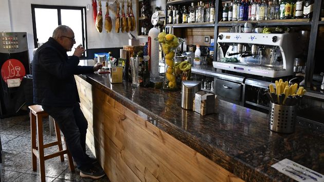Un hombre bebiendo en la barra de un bar