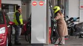 dos personas repostando en una gasolinera