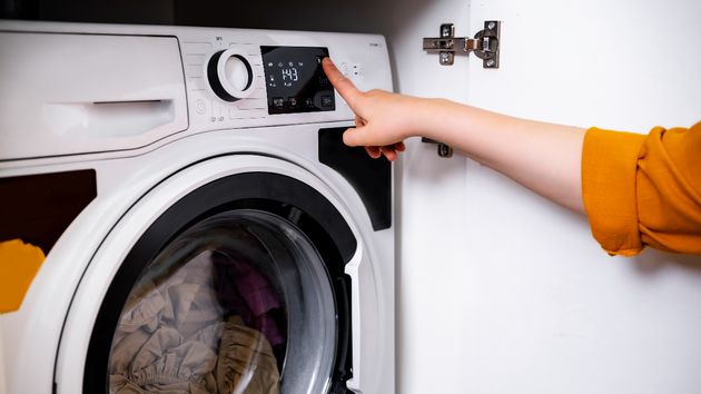 una persona encendiendo la lavadora