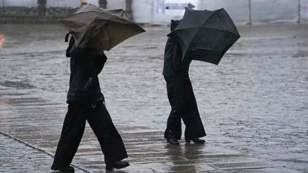 Varias personas intentan sujetar sus paraguas