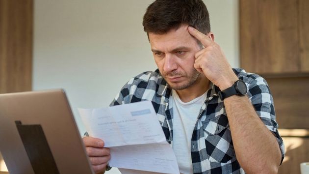 Un hombre preocupado revisando documentos