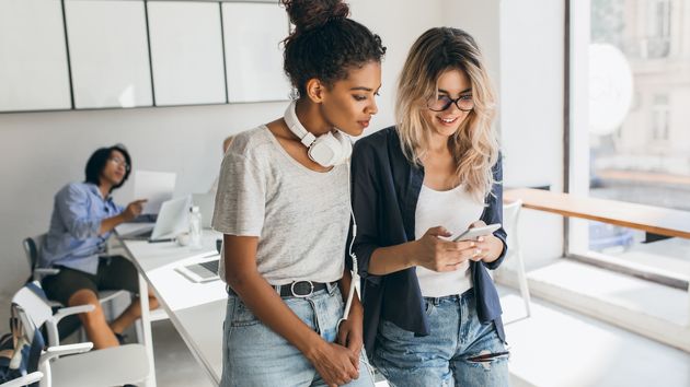Jóvenes trabajadoras mirando el móvil.