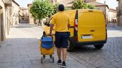 un cartero con su furgoneta y el carro