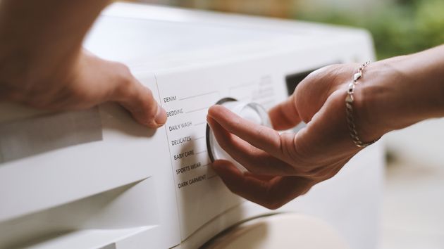 una persona enciende la lavadora