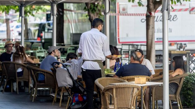 Un camarero atendiendo a los clientes de una terraza