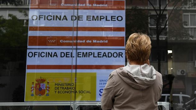 Una mujer mira un cartel en la oficina del SEPE