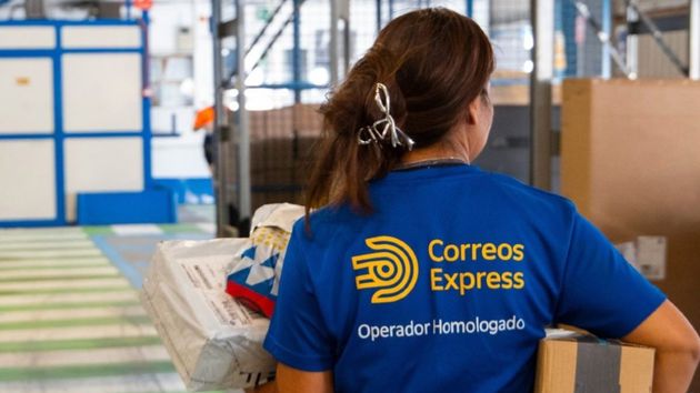 Una trabajadora de Correos Express con varios paquetes