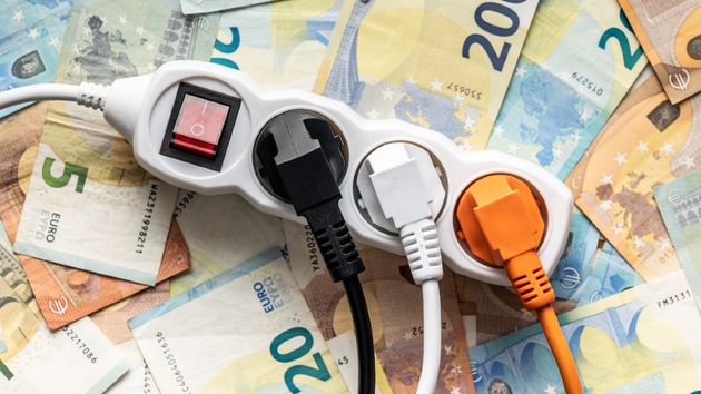 Varios enchufes en una regleta con dinero debajo