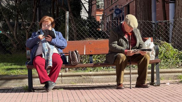 Dos jubilados sentados en la calle