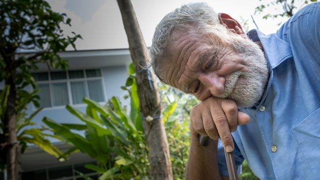 Un hombre mayor apoyado en un baston