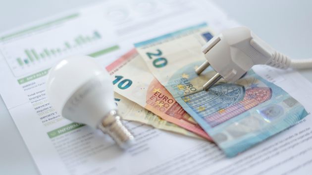 Una factura de luz con dinero en efectivo