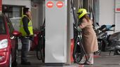 Dos personas repostando en una gasolinera
