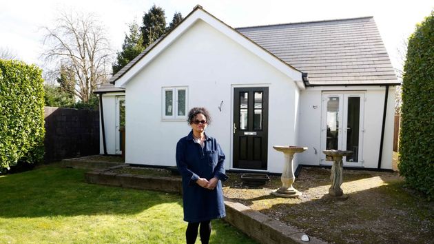 La mujer delante de la casa prefabricada 