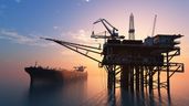 Un barco navegando junto a una torre de petróleo