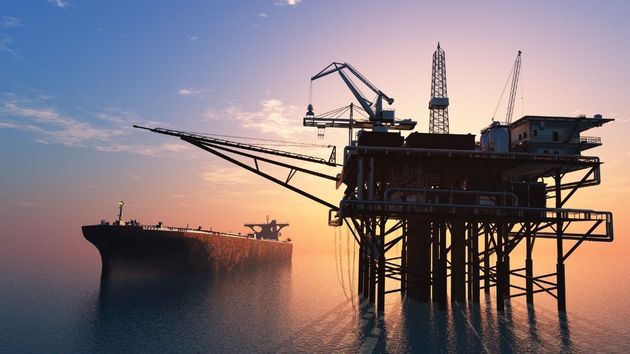Un barco navegando junto a una torre de petróleo