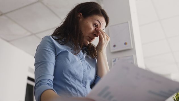 Una mujer agobiada con las manos en la cara