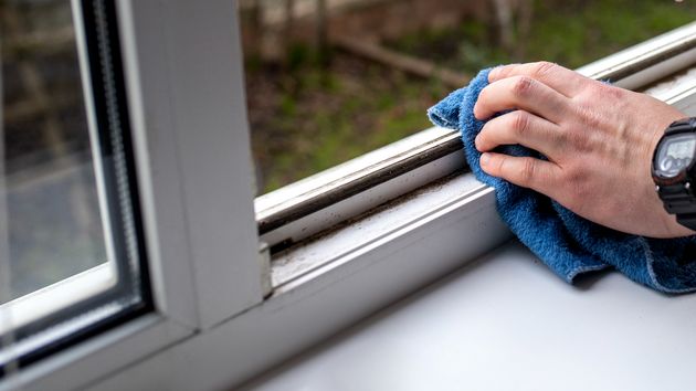 Una mano limpiando una ventana
