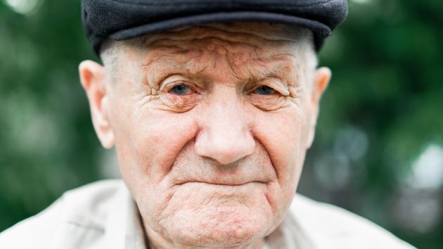 Un anciano con gorra mirando a la cámara