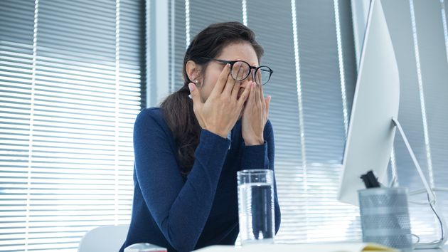 Una mujer cansada frotándose los ojos