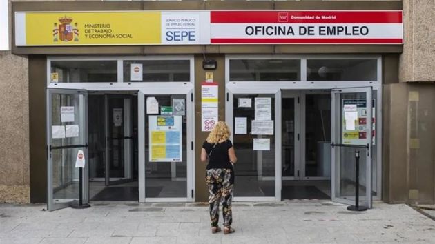 Una mujer delante de una oficina de empleo