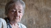 Una mujer mayor mira a la cámara con tristeza