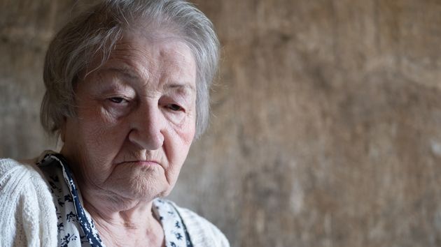 Una mujer mayor mira a la cámara con tristeza