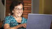 Una mujer mayor mira un portátil