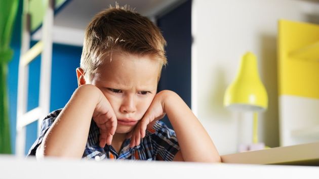 Un niño enfadado en la mesa de clase