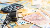 Un enchufe con una calculadora y billetes de euro