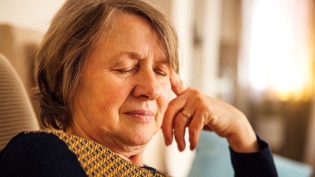 Mujer mayor con la mano en la cabeza