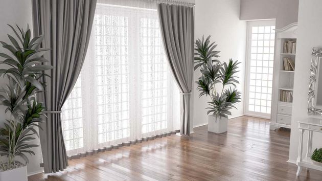 Cortinas instaladas en el ventanal del salón de una casa